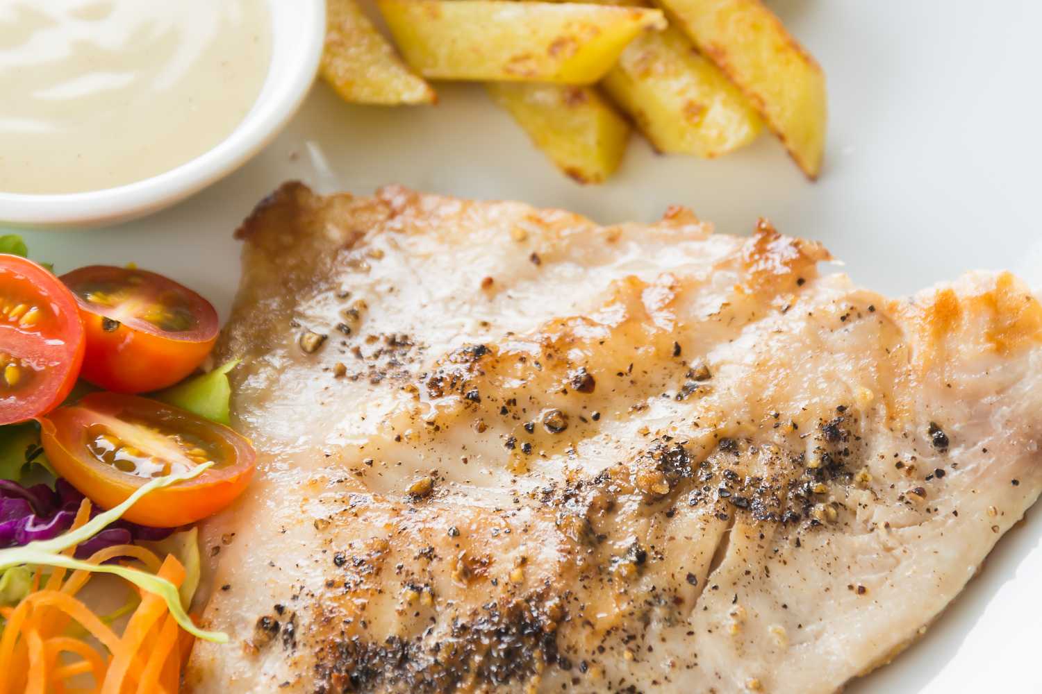 Gepfeffertes Fischfilet mit Tomaten und Pommes